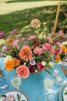 A large, vibrant Wylder centerpiece on a set table