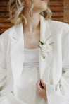 A white Haven boutonniere pinned to a white suit