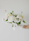 An all-white Haven bouquet against a white wall