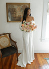 A bride in an off-shoulder gown holding a Chelle bridal bouquet