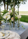 Haven collection flowers in glass vases on a table at an outdoor event 
